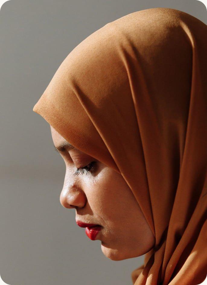 A woman in a headscarf with her eyes closed